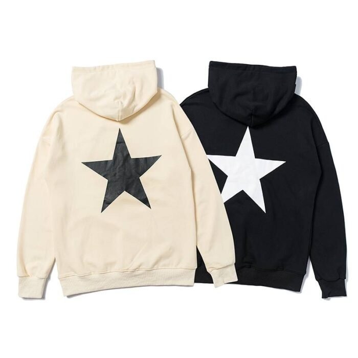 Fear Of God Essentials Hoodie Star A person wearing a Fear of God Essentials hoodie with a star graphic.