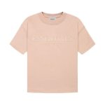 A Fear of God Essentials T-shirt in a soft pink color on a hanger.